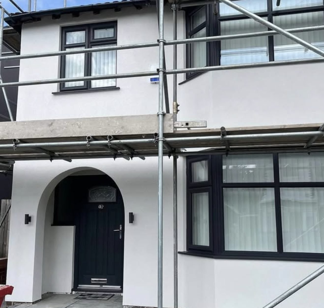 Semi-detached house in new white render with the scaffold still up