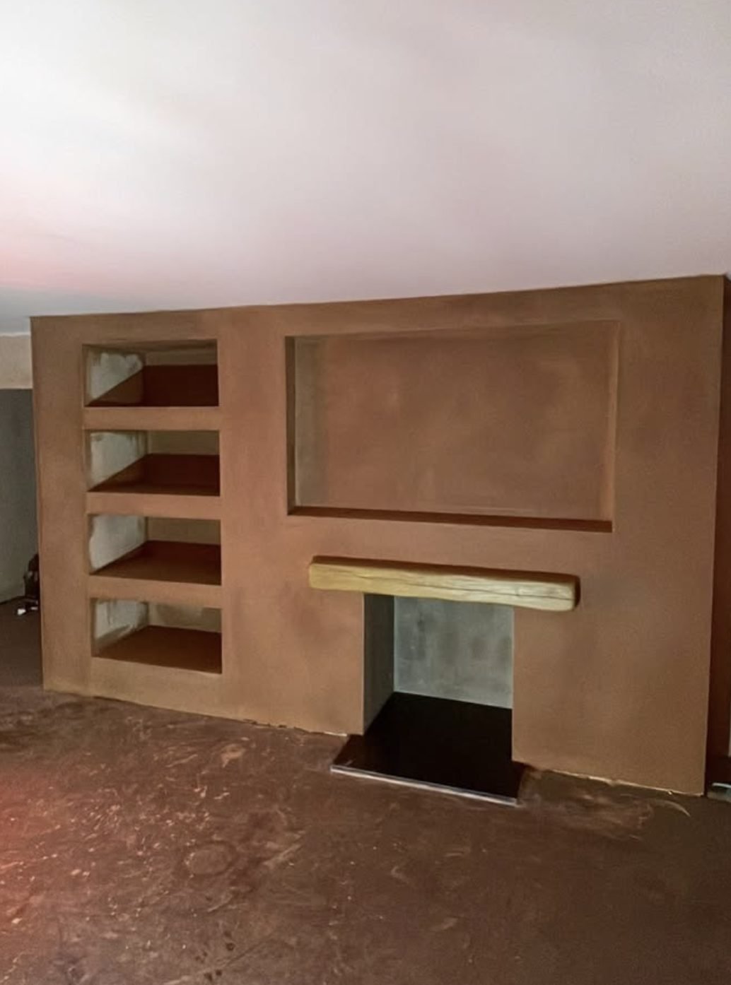 Freshly plastered chimney breast with a fire opening, a TV recess and three alcove shelves