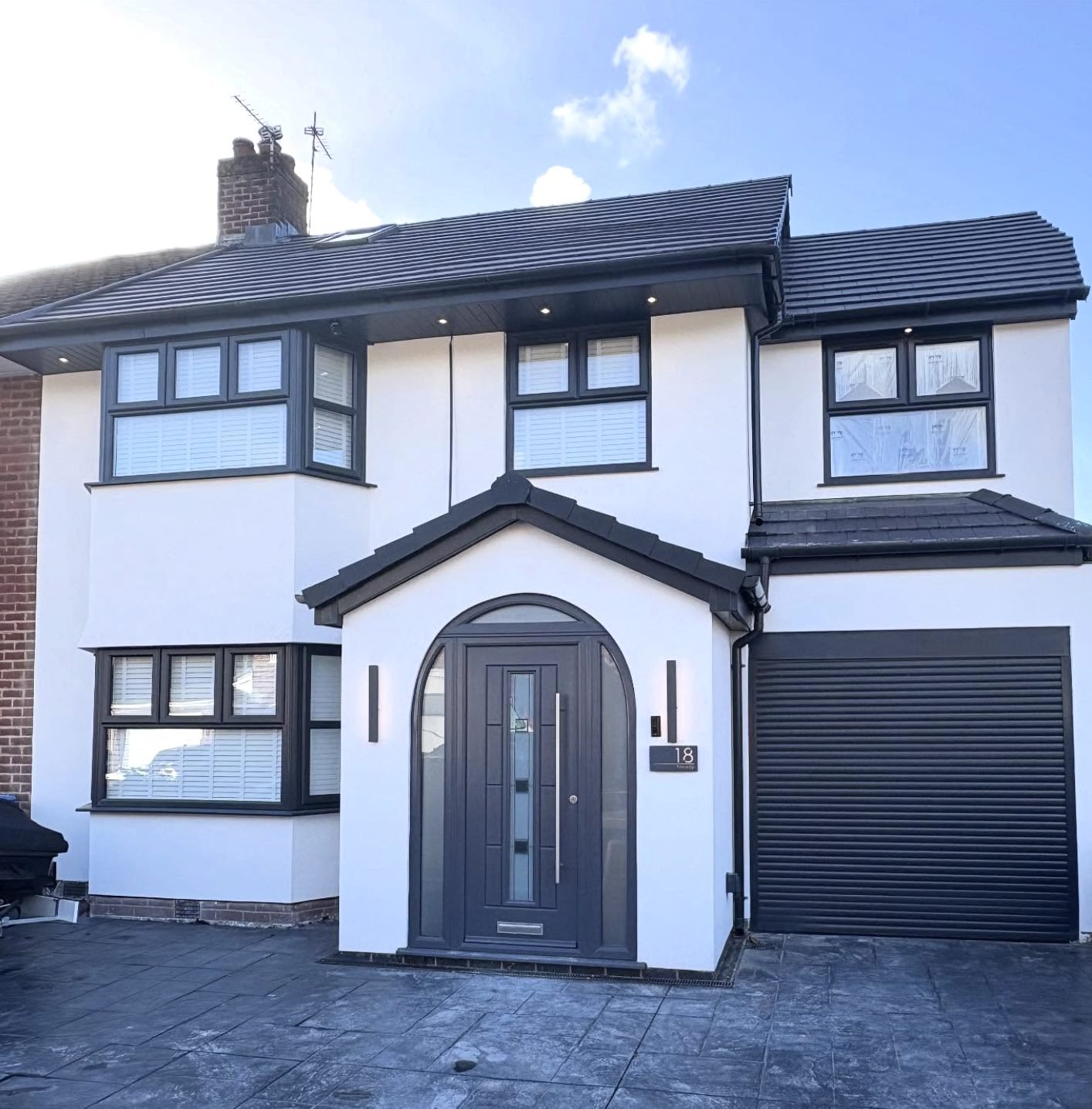 Semi-detached house in white render with a curved porch opening and a garage