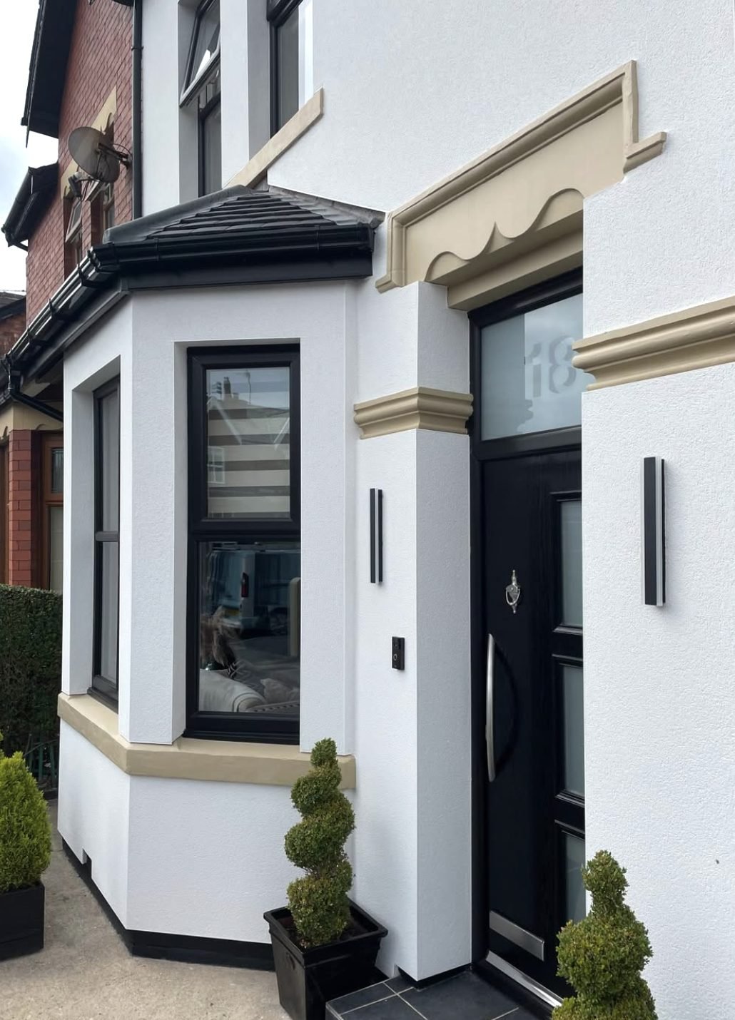 White rendered entrance with a cream surround and band course